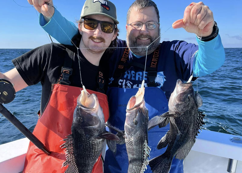 anglers on big worm with sea bass