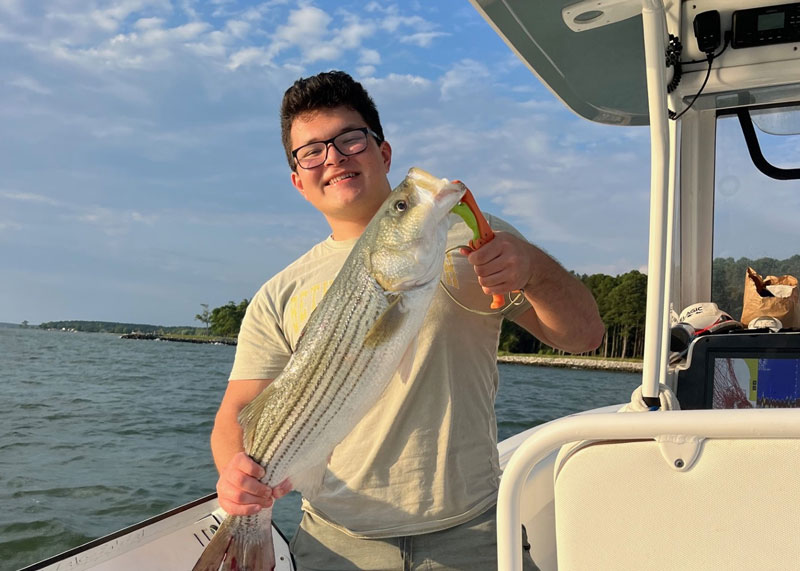 fisherman holding a middle bay rockfish